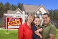 Family in Front of Sold Real Estate Sign and House Royalty Free Stock Photo