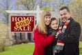 Family in Front of Sold Real Estate Sign and House Royalty Free Stock Photo