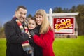 Family in Front of Sold Real Estate Sign and House Royalty Free Stock Photo