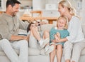 Family fun. an adorable little boy and girl being tickled by their parents on the sofa at home. Royalty Free Stock Photo