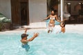 Family Fun In Pool. Mother And Son Jumping In Water With Splashes. Parents And Kid Enjoying Leisure On Weekend.