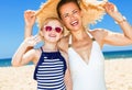 Happy modern mother and daughter on seacoast handwaving Royalty Free Stock Photo