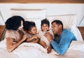 Family, funny and kids laughing in bed at home in the morning together with their happy parents. Relax, love or smile Royalty Free Stock Photo