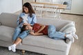 Family gadget addiction. Mother and teen daughter using smartphones while resting together on sofa