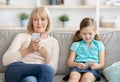 Mature woman and granddaughter using cell phones Royalty Free Stock Photo