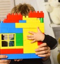 Male hands and child hold colorful toy bricks construction.