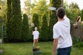 Cheerful dad outside playing badminton with his son in a white T-shirt Royalty Free Stock Photo