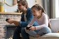 family, gaming and entertainment concept - happy father and little daughter with gamepads playing video game at home. Royalty Free Stock Photo