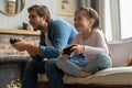 family, gaming and entertainment concept - happy father and little daughter with gamepads playing video game at home. Royalty Free Stock Photo