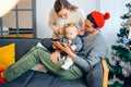 Family gathered around a Christmas tree, using a tablet Royalty Free Stock Photo