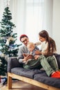 Family gathered around a Christmas tree, using a tablet Royalty Free Stock Photo