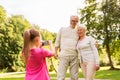 Granddaughter photographing grandparents at park Royalty Free Stock Photo