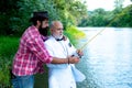 Family and generation - summer holidays and people concept. Man fisherman catches a fish. Brown trout fish. Happy father Royalty Free Stock Photo