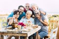 Family generations enjoy and celebrate with fun all together laughing and smiling posing for a picture outdoor at home - table Royalty Free Stock Photo