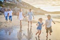 Family, generations and kids with running, beach and sunset with men, women and happiness with love. Parents Royalty Free Stock Photo