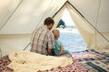 Family glamping. Father and his toddler son inside big camping tent with cozy interior. Luxury travel accomodation into the forest