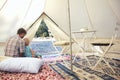 Family glamping outdoor vacation. Father and his toddler son inside big camping tent with cozy interior. Luxury travel