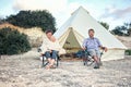 Family glamping outdoor vacation. Mother, father and toddler son sitting near big retro camping tent with cozy interior. Luxury