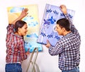 Family glues wallpaper at home. Royalty Free Stock Photo