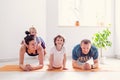 Family goes sports at home together. Mom dad baby doing yoga exercises