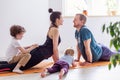 Family goes sports at home together. Mom dad baby doing yoga exercises