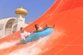Family going down a water slide at a water park in summer. Royalty Free Stock Photo