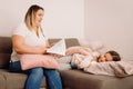 Family before going to bed mother reads to her child daughter book in the evening sitting on the sofa. Royalty Free Stock Photo