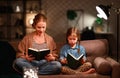 Family before going to bed mother reads to her child daughter book near a lamp in evening Royalty Free Stock Photo