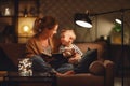 Family before going to bed mother reads to her child son book near a lamp in evening Royalty Free Stock Photo