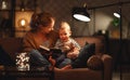 Family before going to bed mother reads to her child son book near a lamp in evening Royalty Free Stock Photo