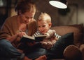 Family before going to bed mother reads to her child son book near a lamp in evening Royalty Free Stock Photo