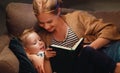 Family before going to bed mother reads to her child son book near a lamp Royalty Free Stock Photo