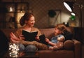 Family before going to bed mother reads to her child daughter book near a lamp in evening Royalty Free Stock Photo