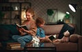 Family before going to bed mother reads to her child daughter book near a lamp in evening Royalty Free Stock Photo