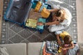 Family going on a trip or vacation, mother packing a suitcase, child playing next to a toy car