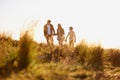 Family, grass and walk at sunset, nature and bonding with exercise for parents and children. Lens flare, autumn and hike Royalty Free Stock Photo
