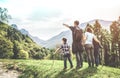 Family on a green meadow looking at the mountain panorama