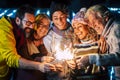 Family group celebrate together with joy the new year eve time with fire sparklers - people enjoying holidays in outdoor with cold Royalty Free Stock Photo