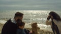 Family group making photos together at sunlight sea beach. People enjoy nature. Royalty Free Stock Photo