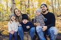 Family Group Relaxing Outdoors In Autumn Landscape sit on log Royalty Free Stock Photo