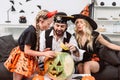 family in halloween costumes on sofa at coffee table with pumpkins Royalty Free Stock Photo