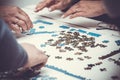 Family hands solving jigsaw