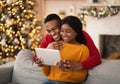 Family happy millennial african american husband and wife look at tablet and congratulate friends