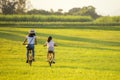 Family Happy. Mother and daughter smiling happy outdoor with bicycling at the garden meadow in sunset
