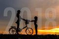 Family Happy new year card 2018. Silhouette biker lovely family at sunset over the ocean. Royalty Free Stock Photo