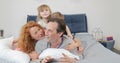 Family happy smiling lying together on father in bedroom, cheerful parents with children in morning