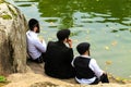 A family of Hasidic Jews, 3 boys, in traditional black clothes sitting in the autumn park,