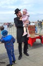 A family of Hasidic Jews, a man with children, walking at the festival. Religious Orthodox Jew with a girl. Dnipro city,