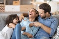 Family have fun daughter and daddy tickling mother