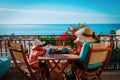 Family having breakfast on balcony terrace with sea view